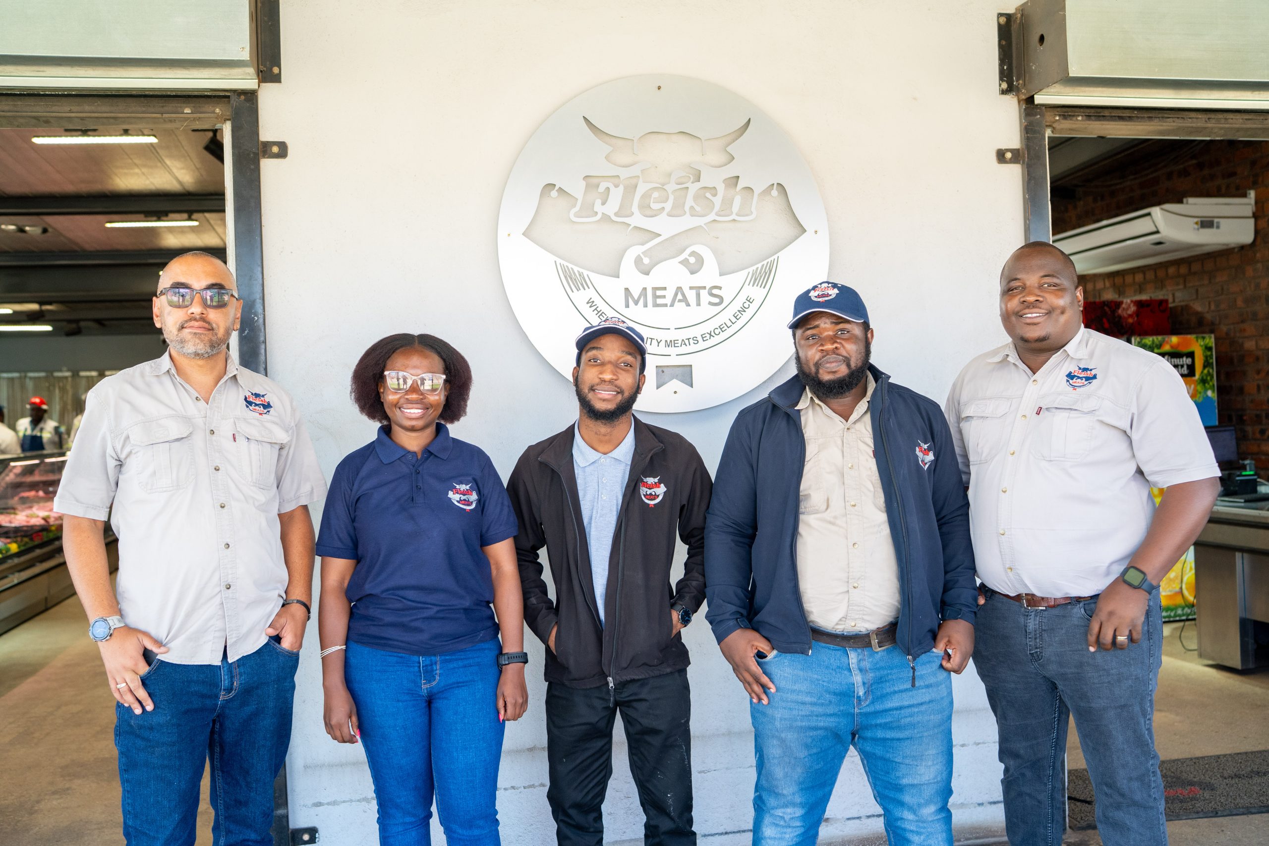 The Fleish Meats team in front of the shop signage